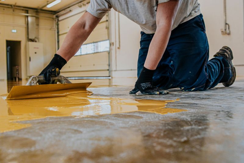 worker applying epoxy mixture on the floor