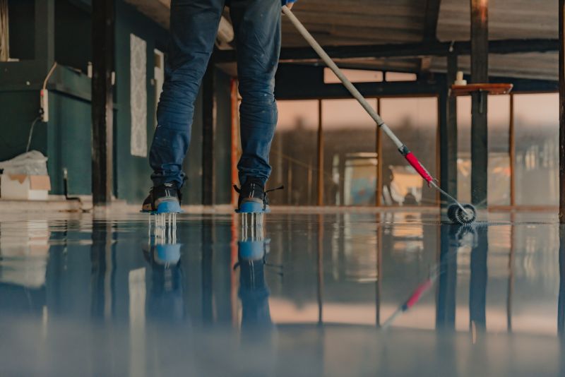 worker using a roller to level the epoxy coating